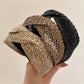 Close-up of Gifty chic woven cross headband in beige on white background