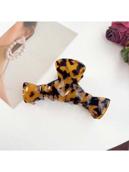 Beau claw clip placed on wooden surface with natural light