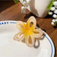 Beau openwork flower hair claw clip shown with packaging box