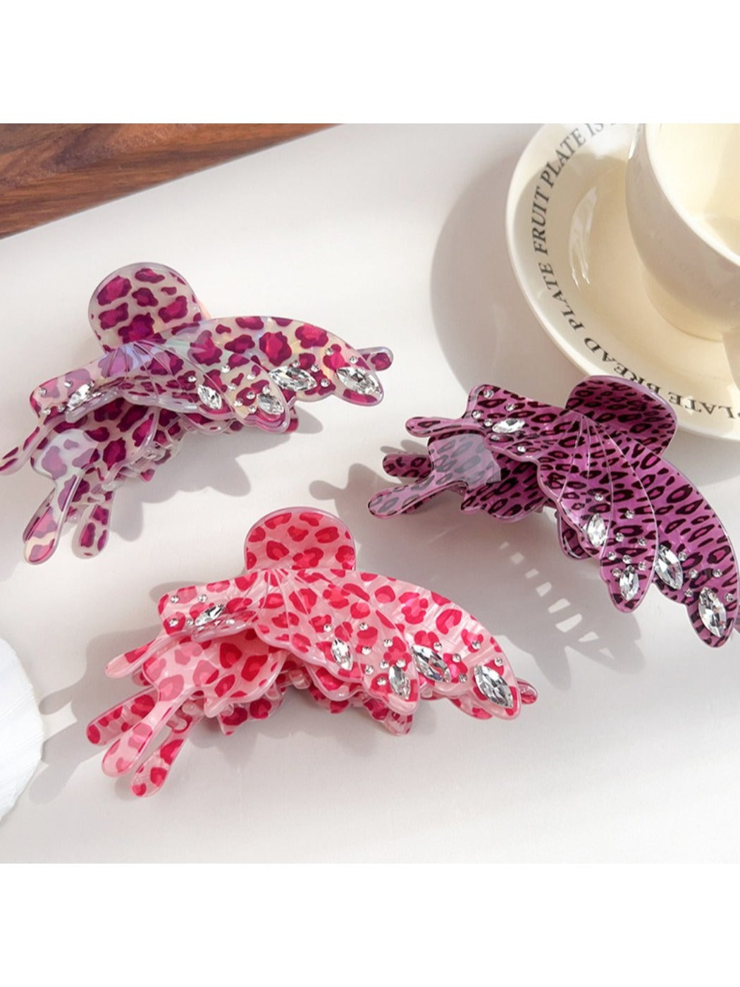 Beau leopard print butterfly claw clip held in hand for size reference