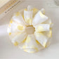 Yellow polka dot scrunchie styled on a wrist as an accessory