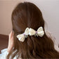 Beau printed bow banana clip worn in long hair, styled in half-updo
