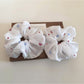Close-up of minimalist white flower scrunchie with soft fabric texture
