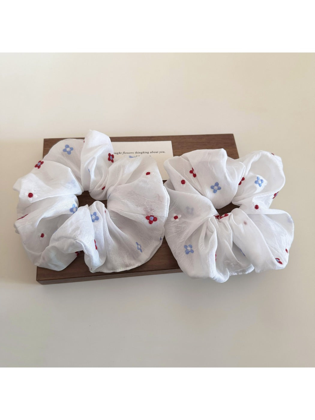 Close-up of minimalist white flower scrunchie with soft fabric texture