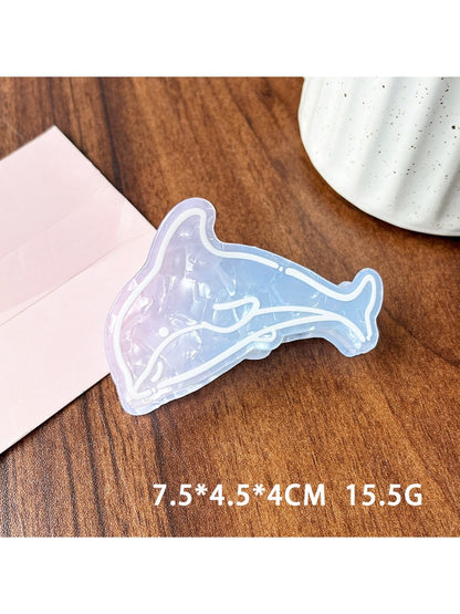Beau blue ocean style claw clip next to seashells for thematic styling
