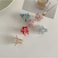 Side view of Beau sweet flower shaped small claw clip in pastel pink