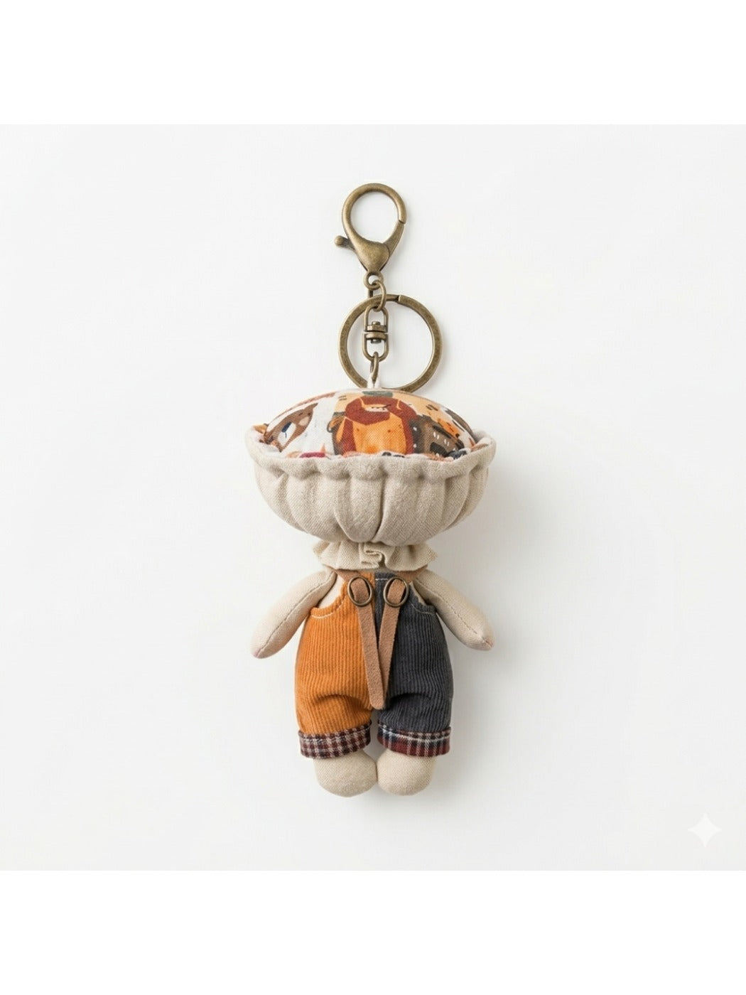 Keypus fabric doll keychain hanging from a backpack strap