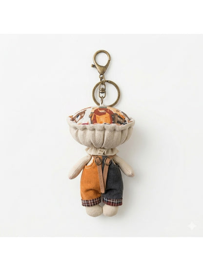 Keypus fabric doll keychain hanging from a backpack strap