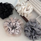 Close-up of Gifty fashionable cut out ruched scrunchie in soft pink fabric