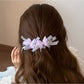Side view of the Beau banana clip highlighting its curved shape and butterfly decorations