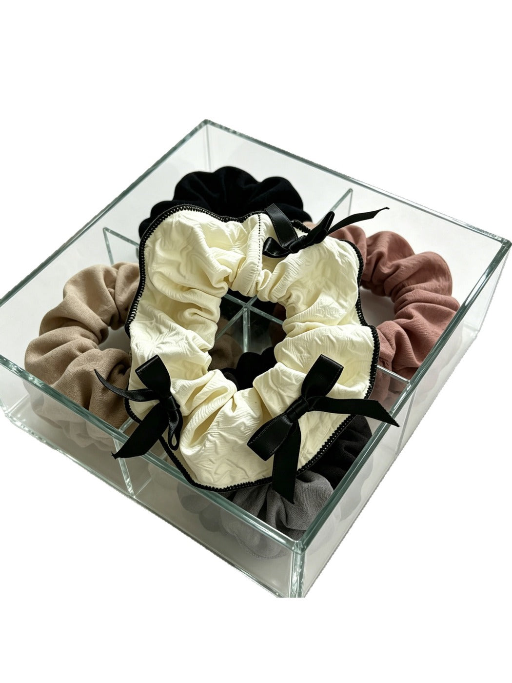 Close-up of Gifty scrunchie with red ribbon bow on a white background