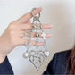Heart shaped charm keychain attached to a silver keyring with a white backdrop