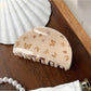 Beau brown butterfly print claw clip displayed on a wooden surface