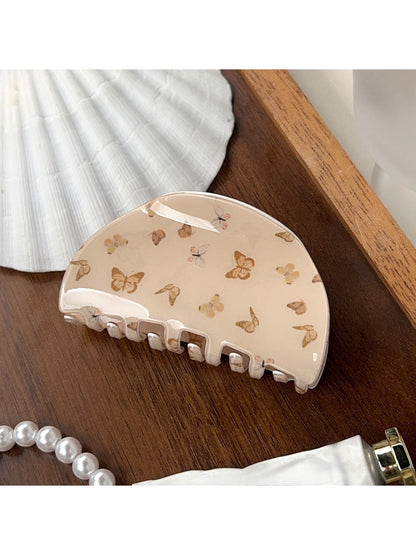 Beau brown butterfly print claw clip displayed on a wooden surface