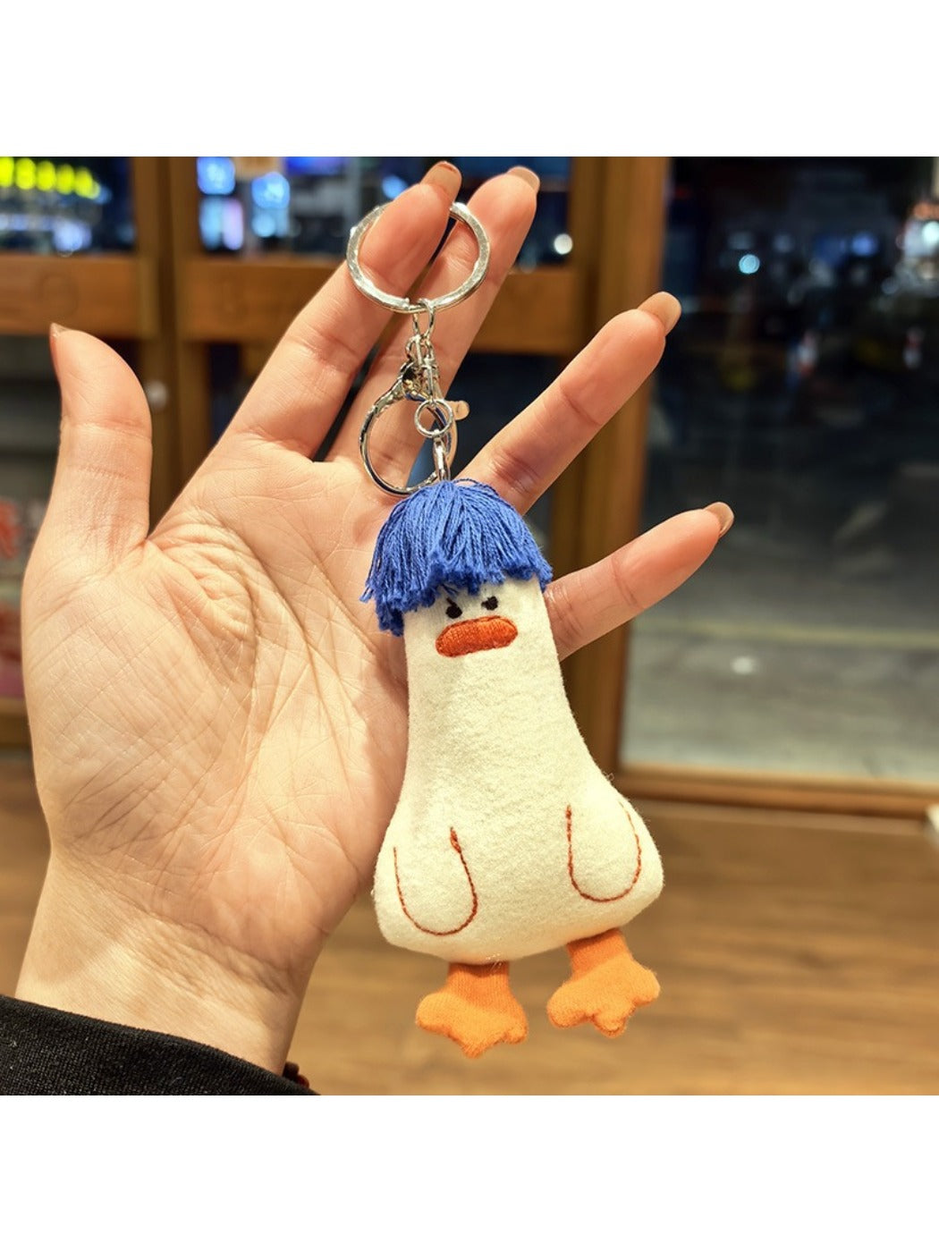 Side view of blue duck hair keychain highlighting its rounded shape