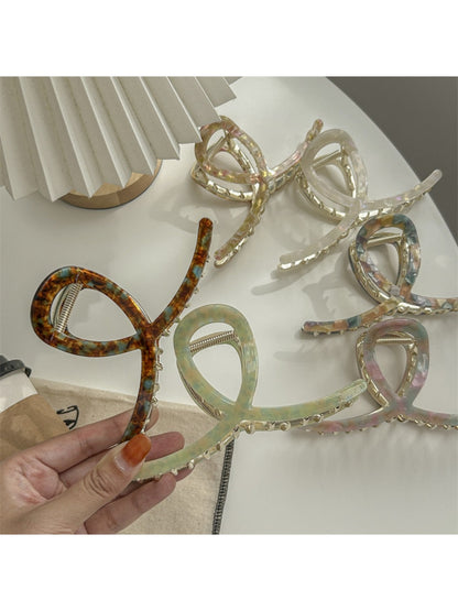 Beau large acetate claw clip holding thick hair in an updo style