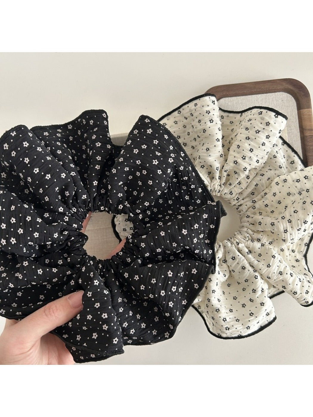 Gifty large floral scrunchie styled on a wrist as an accessory