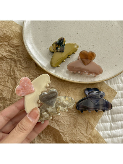 Beau heart shaped acetate claw clip held in hand to show size and shape