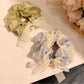 Soft lace bow hair tie in light pink on a white background