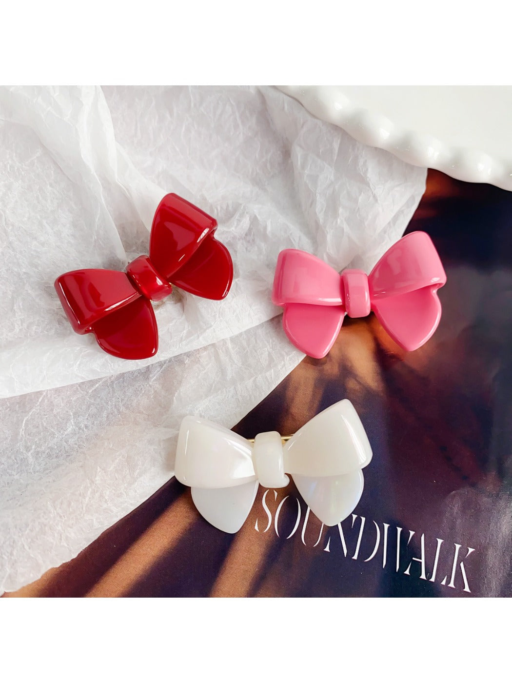 Close-up of Beau delicate bow hair clip showing textured fabric and gold detailing