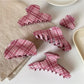 Beau pink plaid hair claw clip held in hand showing size and pattern
