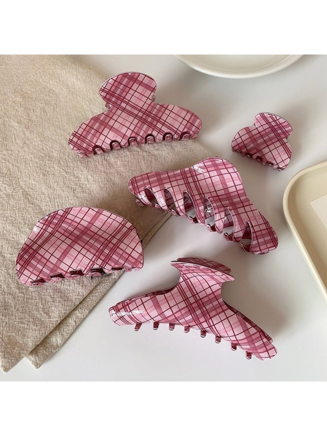 Beau pink plaid hair claw clip held in hand showing size and pattern