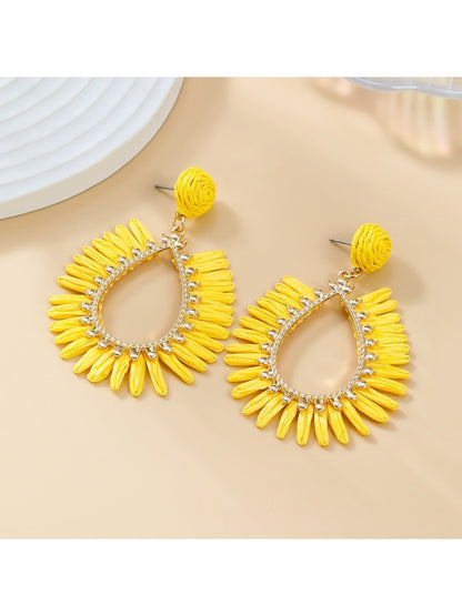 Earedge minimalist oval raffia drop earrings hanging from a white ceramic stand