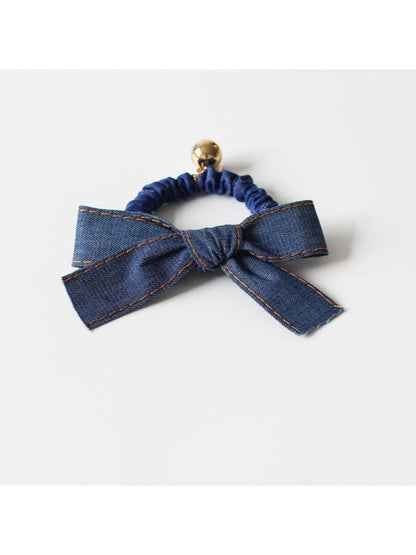 Model wearing vintage bow hair tie with casual outfit and loose hair strands