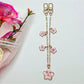 Cherry blossom pendant attached to a black handbag strap as a decorative charm