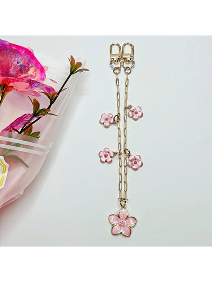 Cherry blossom pendant attached to a black handbag strap as a decorative charm
