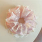 Close-up of Gifty sweet printed ruffled scrunchie with pastel floral pattern