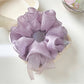 Close-up of purple bow scrunchie showing fabric texture and stitching