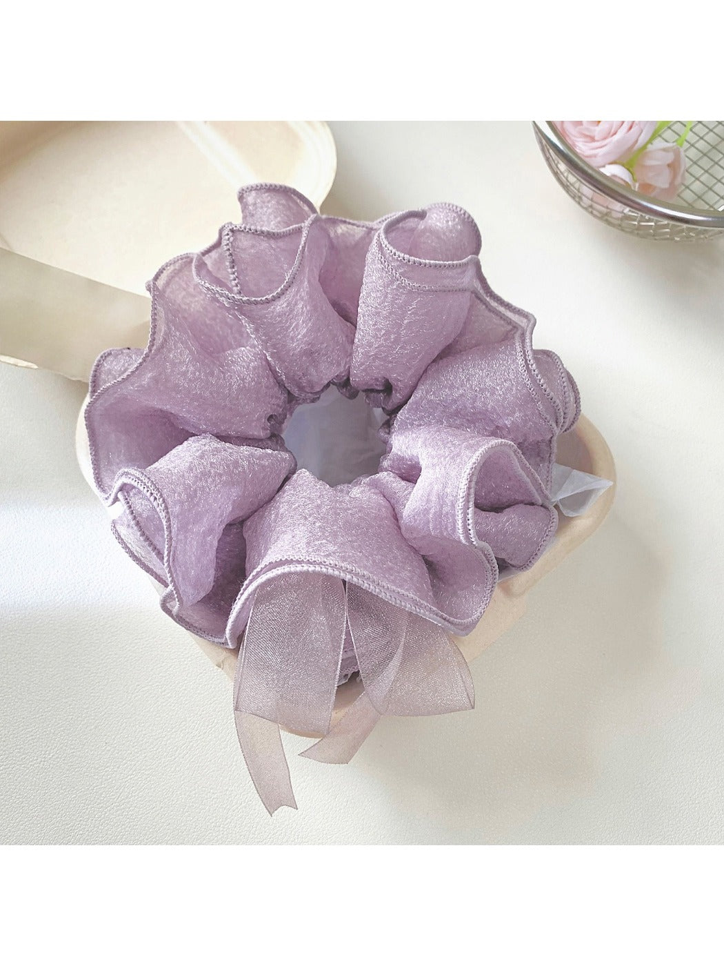 Close-up of purple bow scrunchie showing fabric texture and stitching