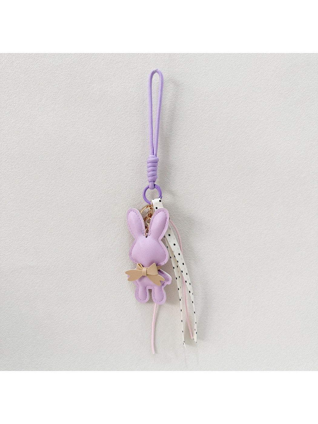 Bunny keychain hanging from a set of keys on a wooden table