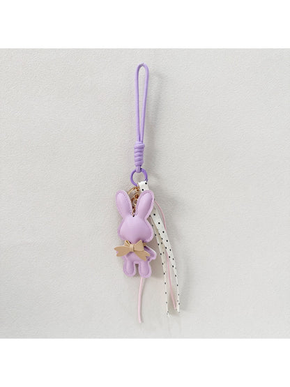 Bunny keychain hanging from a set of keys on a wooden table