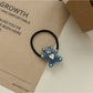 Rose hair tie stretched to show elastic quality and flower detail