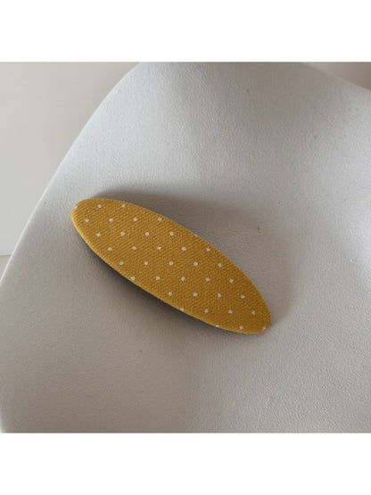 Beau pink hair clip with white dots placed next to matching accessories