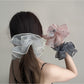 Close-up of Gifty scrunchie showing detailed ruched fabric layers in pink