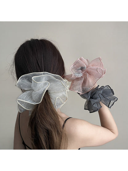 Close-up of Gifty scrunchie showing detailed ruched fabric layers in pink