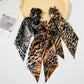 Three snakeskin ribbon bow scrunchies in a display