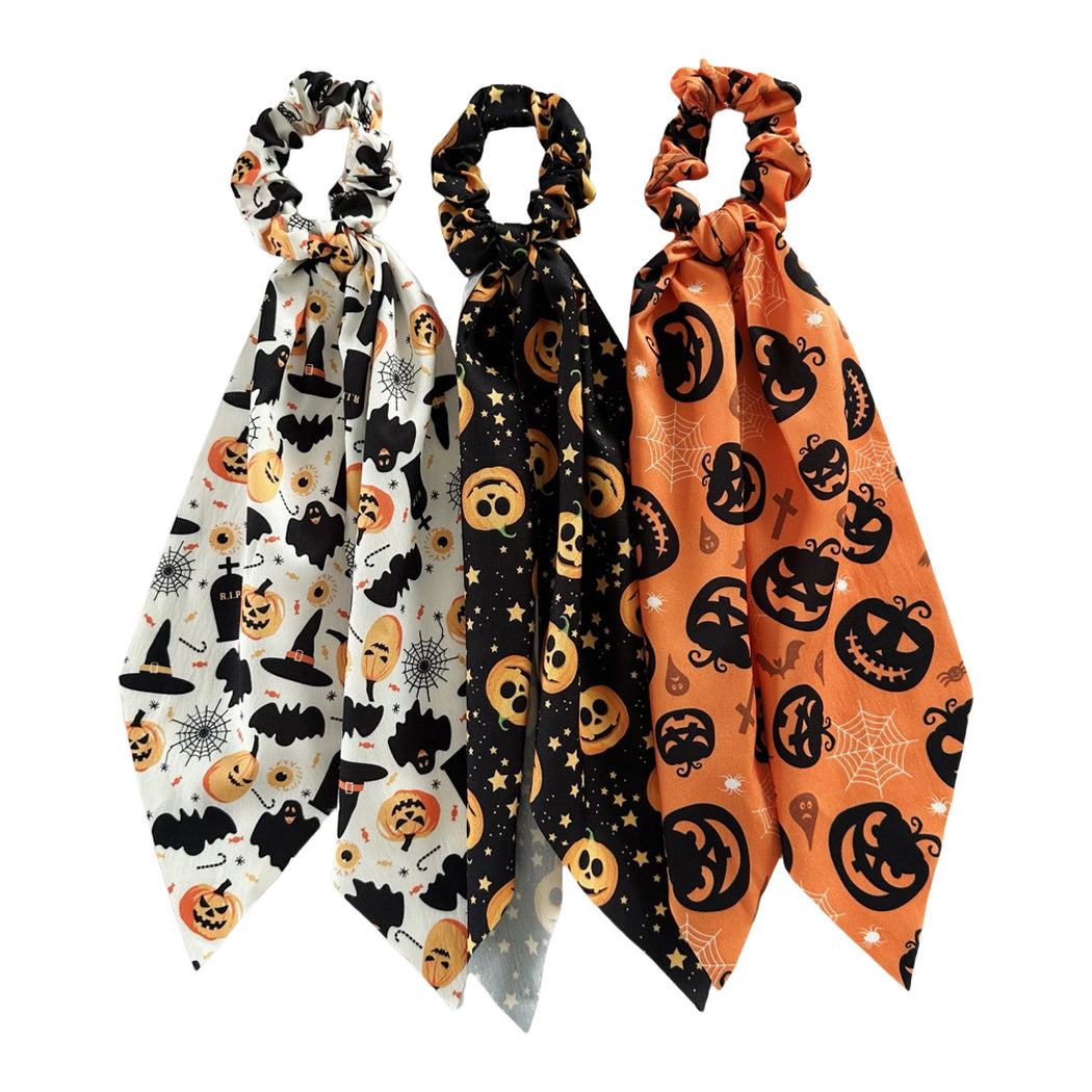 Three Halloween ribbon scrunchies on white background