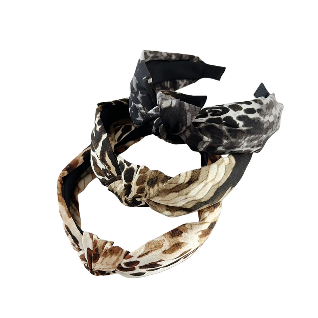 Three snakeskin crossed wide headbands on white background