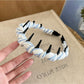 Gifty checkered headband styled with vintage accessories on wooden surface