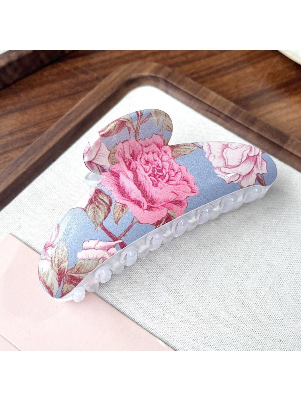 Beau hair clip placed on a white background displaying bright flower motifs