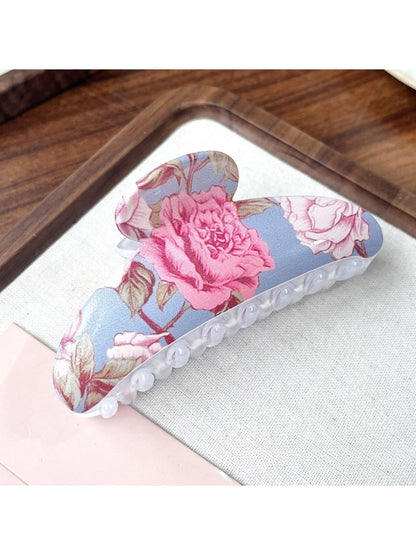 Beau hair clip placed on a white background displaying bright flower motifs