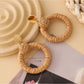 Earedge rattan round hollow earrings held in hand showing size and detail