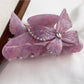 Beau hair claw clip with bright butterfly decorations against a pastel background