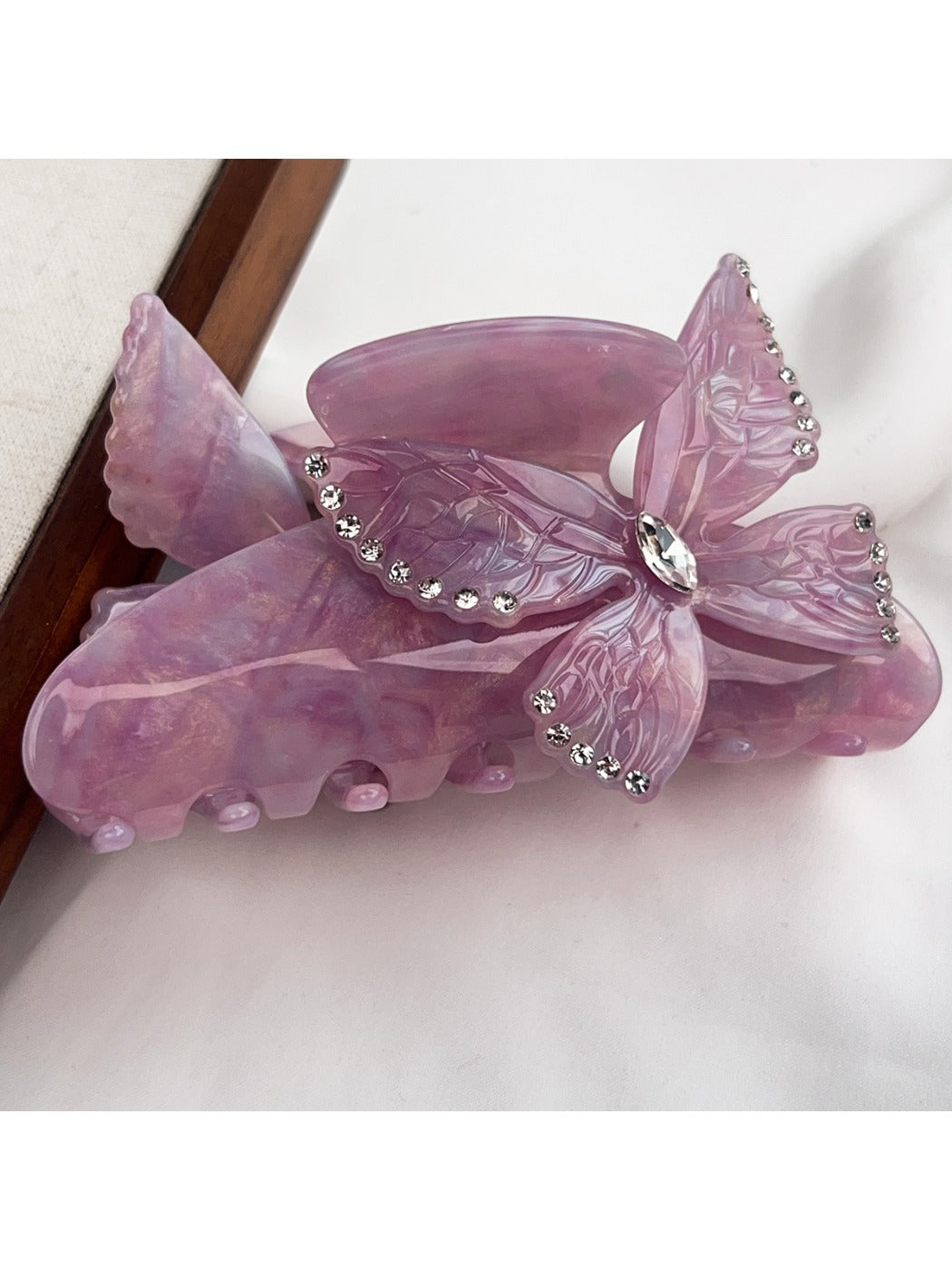 Beau hair claw clip with bright butterfly decorations against a pastel background