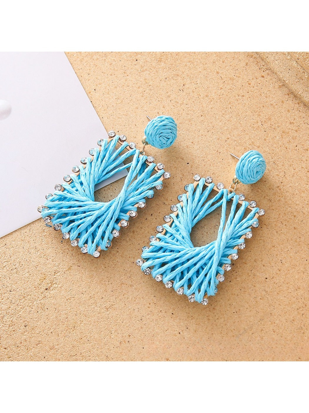 Close-up of woven raffia detail on square shape drop earrings