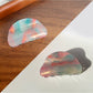 Beau colorful hair claw clip placed on wooden surface